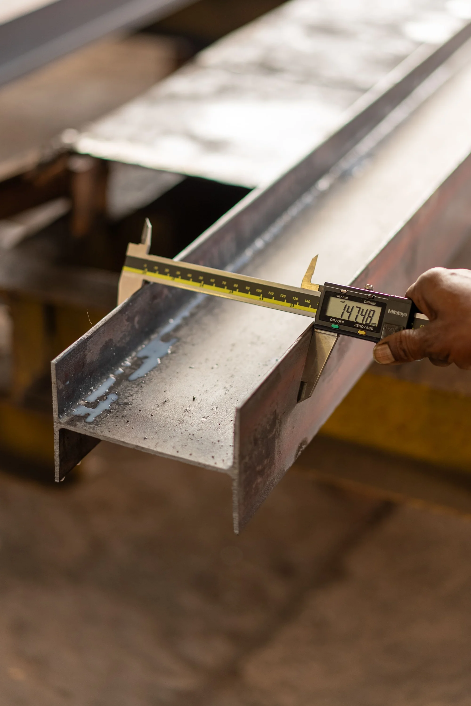 A digital caliper measuring a steel component